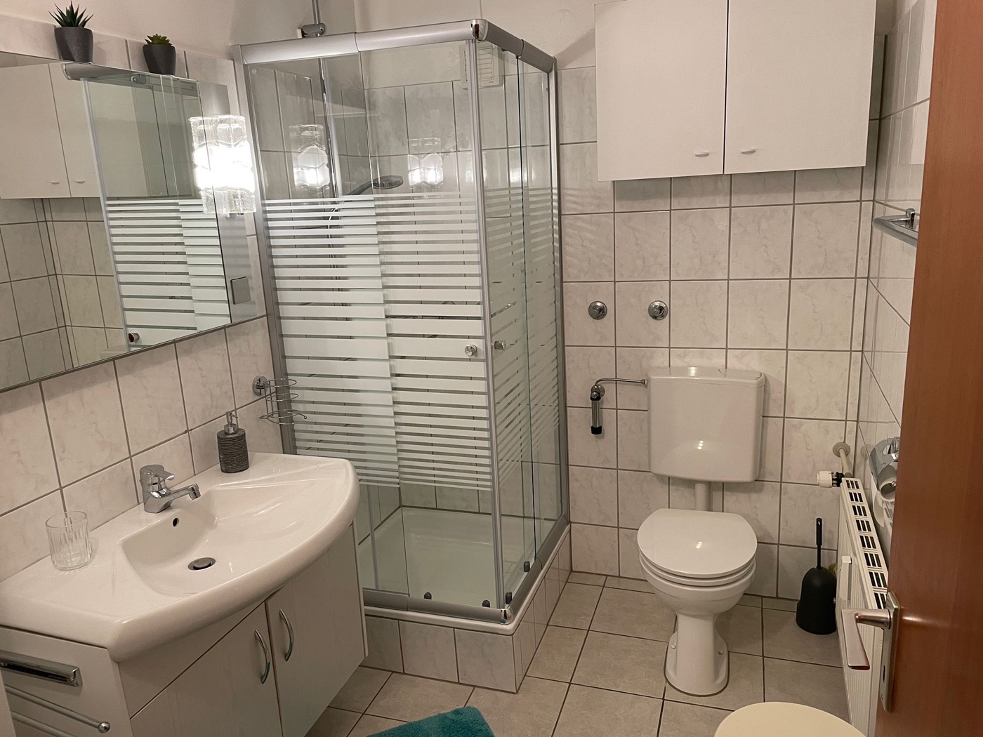 Bad mit Dusche, Waschbecken, Spiegelschrank und WC