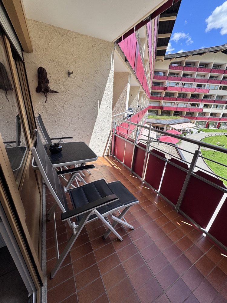 Balkon mit Tisch und Stühlen, Blick auf den Innenhof der Anlage