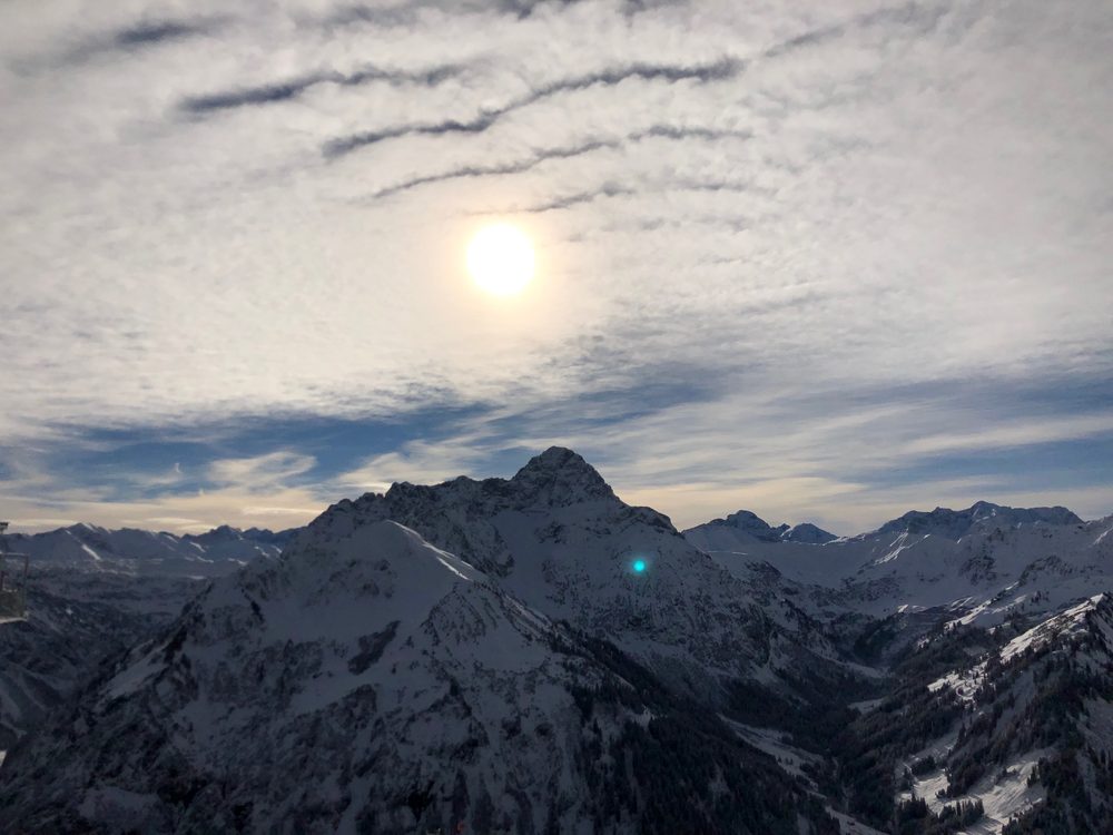 Winterpanorama im Kleinwalsertal mit Blick auf verschneite Gipfel und Skipisten